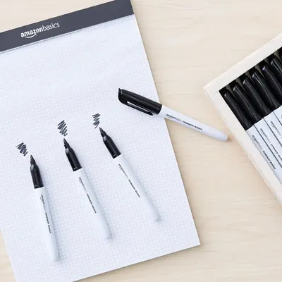Shows the customer what comes in the package: multiple permanent markers and an AmazonBasics notepad, demonstrating the value and completeness of the set.