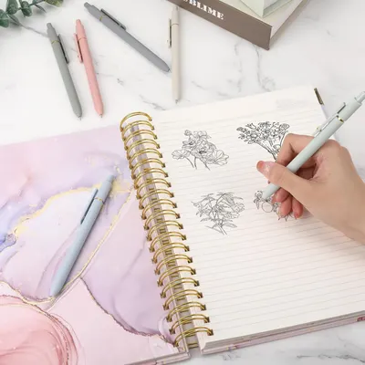 Shows the product being used in a real-world lifestyle setting to help shoppers visualize how they would use the notebook in their daily life.