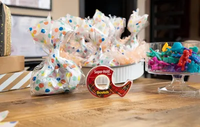 Shows the product in a real-world party or crafting context to help shoppers visualize how the tape fits into everyday creative and gift-wrapping scenarios.