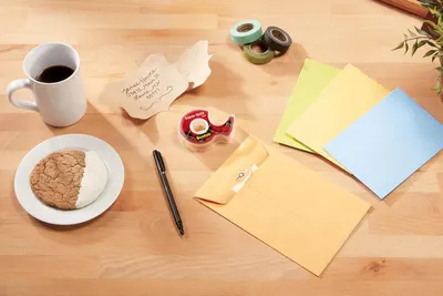 Shows the Scotch tape dispenser in a real-world office or home workspace context to help shoppers visualize the product in everyday use.