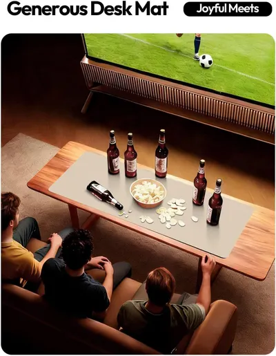 Demonstrates the desk mat in a real-world social setting, showing how it creates a generous surface for group activities like watching sports and sharing snacks and drinks.