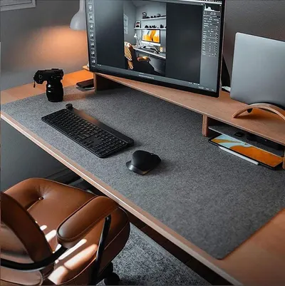 Showcases the product (desk mat/pad) in a real-world home office setting to help shoppers visualize how it fits into a modern, professional workspace.