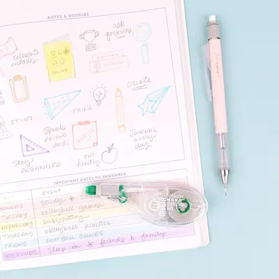 Displays the product (planner and pen/correction tape) in a clean, lifestyle setting to show what the customer receives and how it looks in use.