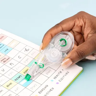 Demonstrates the product being used in a real-world setting (studying/planning) to help shoppers visualize how the correction tape fits into their daily routine.