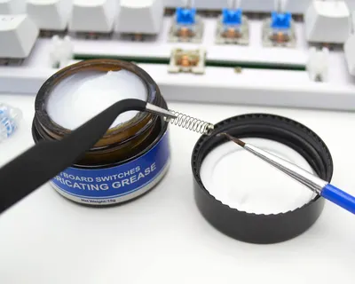 Demonstrates the product's use for keyboard switches, showing the grease container and application tool to communicate ease of maintenance and lubrication.