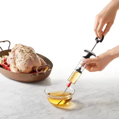 Demonstrates how to use the marinade injector to baste or inject liquid into meat, showing the product in action to help shoppers understand its usage.
