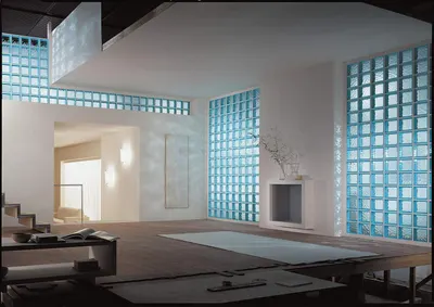Showcases the product (glass block walls) in a real-world modern interior setting to help shoppers visualize how it looks in an actual space, emphasizing aesthetic appeal and natural light diffusion.
