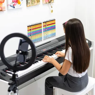 Shows the product being used in a real-world piano learning environment to help shoppers visualize how the chart fits into their practice space.