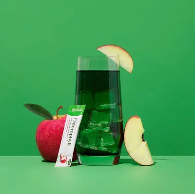 Shows the product mixed in a glass with ice and apple garnish in a lifestyle setting to demonstrate how the product looks when prepared and ready to consume.