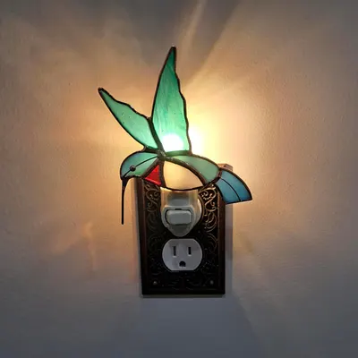 Displays the night light plugged in and glowing in a real-world environment to show its ambient lighting effect.