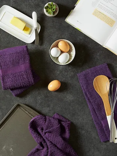 Displays the towels in a natural kitchen baking scene to demonstrate everyday use and fit within home decor.