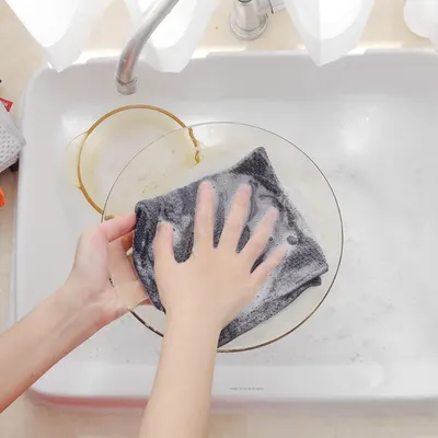 Shows the product in real-world use for cleaning dishes in a kitchen setting.