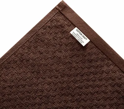 Highlights the physical construction of the mat corner and shows the brand label placement.