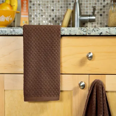 Displays the mat hanging on a kitchen cabinet to show how it looks in a real home setting.