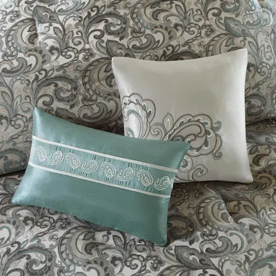 Provides a detailed view of the decorative pillows showing embroidery and design details on the bedding.