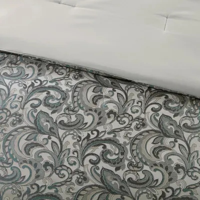 Displays the jacquard pattern detail of the comforter with the fitted sheet to show the design and quality of the fabric.
