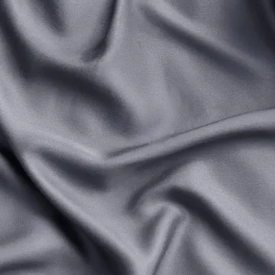 Showcases the luxurious silky texture and quality of the sheet fabric in a close-up detail shot.
