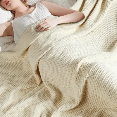 Displays the blanket in a real-world relaxation scenario to help shoppers visualize comfort and softness without any text overlays.