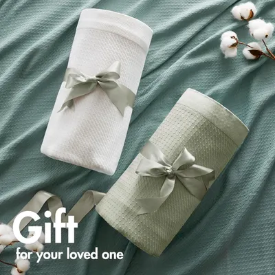 Positions the product as a gift option by showing it wrapped with decorative ribbons and cotton accents.