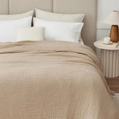 Displays the blanket on a bed in a home setting to demonstrate its aesthetic appeal and drape.