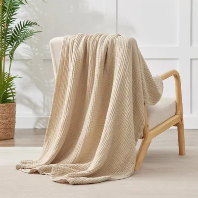 Shows the blanket draped over a chair to demonstrate its versatility and texture in a living space.