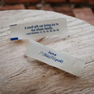 Shows the fortune message slips inside the cookies to communicate the fun, traditional fortune cookie experience and gifting appeal.