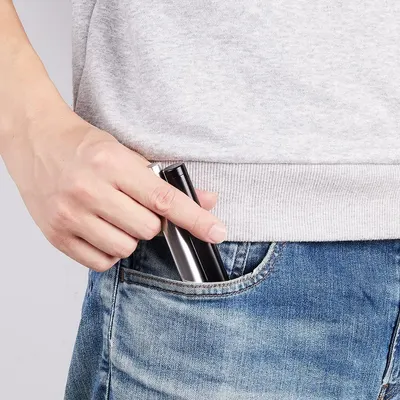 Shows the product in a real-world context being placed in a pocket, demonstrating portability and everyday convenience.