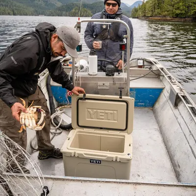Shows the cooler in a real-world fishing scenario on a boat, demonstrating its practical use in outdoor environments without any text overlay or feature…