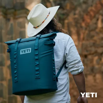 Shows the backpack in a real-world outdoor setting to help shoppers visualize the product in use during outdoor activities.