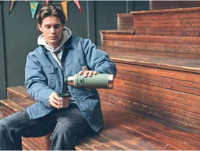 Depicts the thermos being used in an everyday urban setting to show its versatility for daily use and commuting.