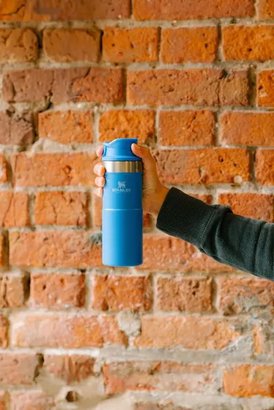 Shows the water bottle being held in a real-world setting to help shoppers visualize the product in everyday use.
