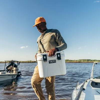 Demonstrates the product in a real-world outdoor setting near water, showing its portability and suitability for outdoor activities like boating and fishing.