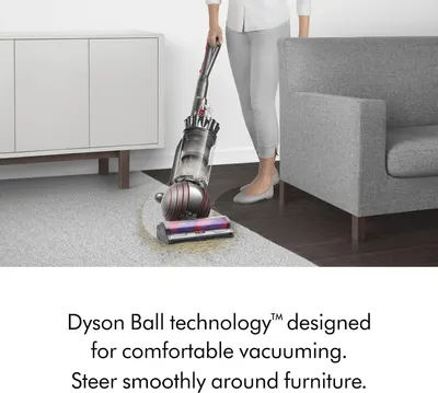 Demonstrates the Dyson Ball technology that enables comfortable vacuuming and smooth steering around furniture, emphasizing ease of use and maneuverability.
