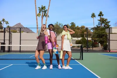 Shows the product in a real-world tennis court setting with people enjoying an active lifestyle, creating an aspirational context for the product without any…