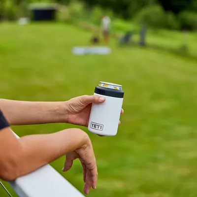 Shows the product in use during an outdoor recreational activity, helping shoppers envision using the colster at casual outdoor gatherings.