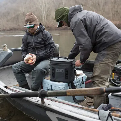 Shows the cooler in a real-world fishing scenario with no text overlay, helping shoppers visualize the product in use during outdoor activities.