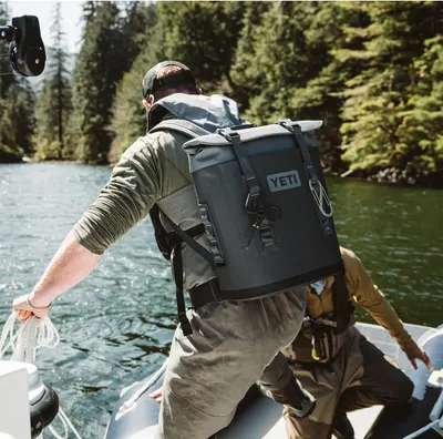Shows the backpack in a real-world outdoor fishing context to help shoppers visualize the product in use.