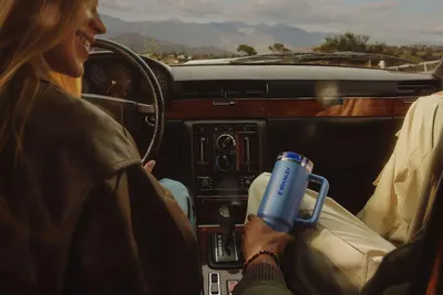 Depicts the product in use during a road trip to help shoppers envision using the tumbler while traveling or commuting.