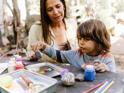 Depicts the product in use during a family arts and crafts activity outdoors, showing real-world application without text overlay.