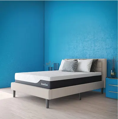 Presents the mattress in a contemporary bedroom with bold blue walls, allowing shoppers to see the product in a real-world setting.