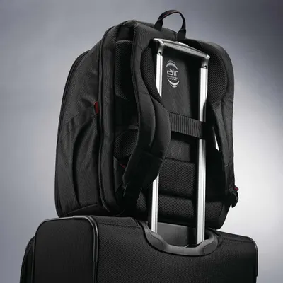 Backpack resting on a suitcase handle shows the trolley sleeve that keeps it secure while traveling.