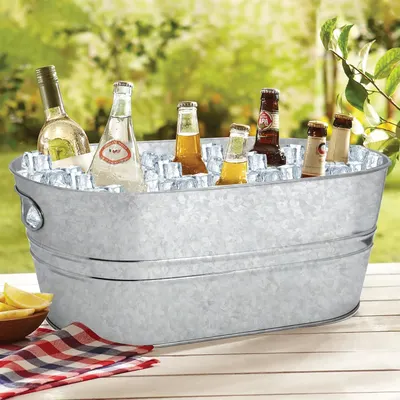Shows the tub filled with ice and drinks on an outdoor table to convey its everyday serving use.
