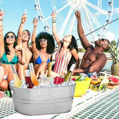 Shows friends enjoying drinks from the tub at a social outdoor event.