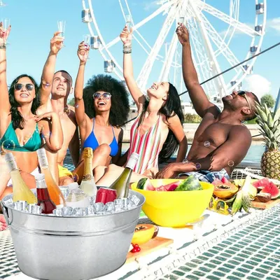 Shows the tub in a lively outdoor party setting to suggest versatile use for gatherings. Conveys that the tub is a fun, party-ready centerpiece for drinks.