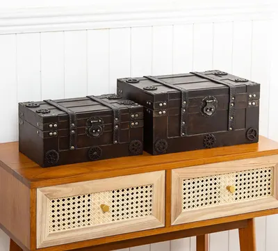 Shows two trunks of different sizes styled together on a console to inspire decor use with no text overlay. Displays the set of matching trunks in different sizes to show the available product line…
