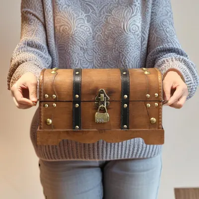 Shows the chest held in hand to convey its small, easy to carry size.