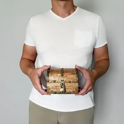 Shows the chest held in two hands to convey a small, easy-to-hold size with a rustic look.