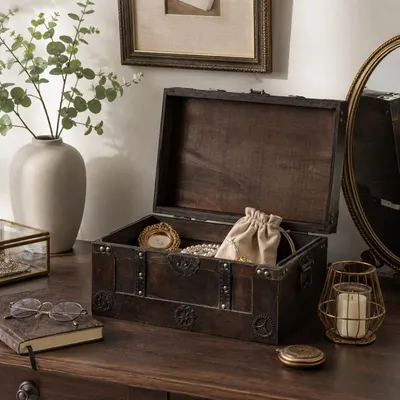 Shows the wooden keepsake trunk styled naturally on a vanity with jewelry inside, helping shoppers picture it in their own home decor.