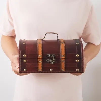 Shows the chest held in hands to convey its compact size and handle-carry convenience.