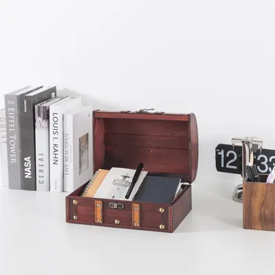 Shows the open chest filled with notebooks and pens to demonstrate its storage use on a desk.